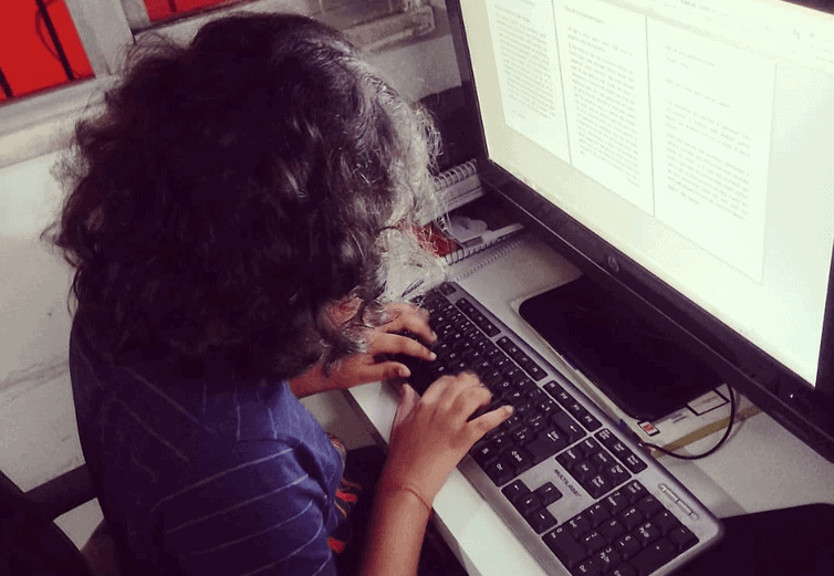 Yalle Tárique digitando em seu computador, onde produziu os relatos sobre a quarentena 